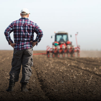 Farm & Ranch SuppliesFarmer standing in front of tractor